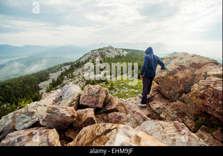 Caucasian hiker standing on rocky hilltop Stock Photo