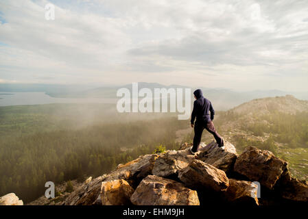 Caucasian hiker standing on rocky hilltop Stock Photo