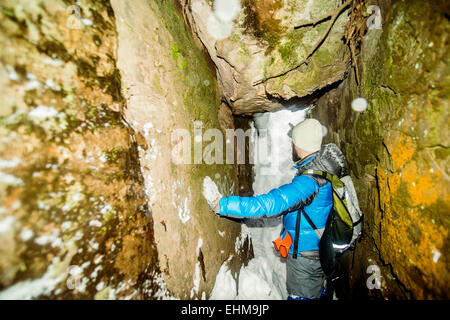Caucasian hiker standing in snowy cave Stock Photo