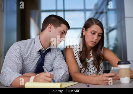 Business people using cell phone in office meeting Stock Photo