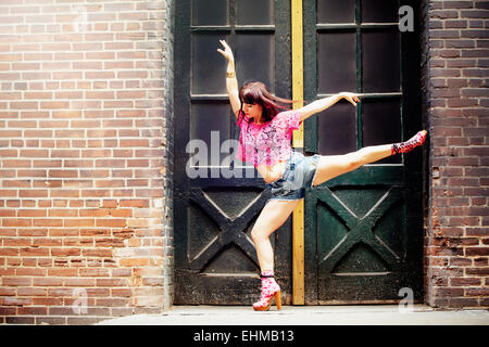 Caucasian woman dancing in doorway Stock Photo