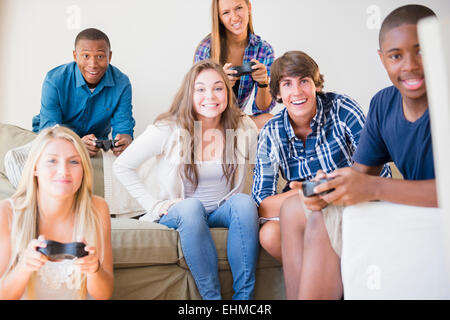 Teenagers playing video games in living room Stock Photo