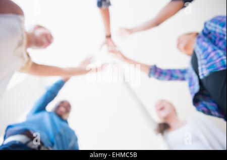 Close up of teenagers cheering with arms outstretched in huddle Stock Photo