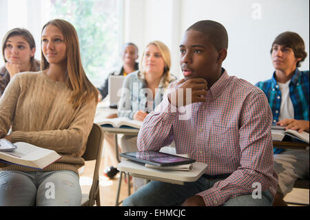 Teenage students listening in classroom Stock Photo