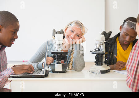 Teenage students using microscopes in science laboratory Stock Photo
