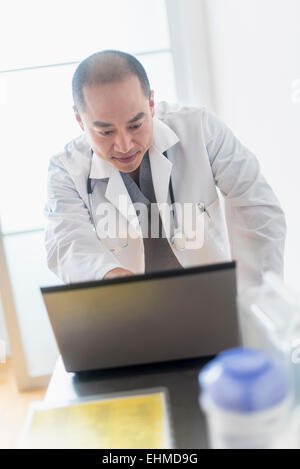 Korean doctor using laptop in office Stock Photo