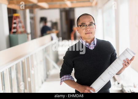 Korean architect carrying blueprints Stock Photo