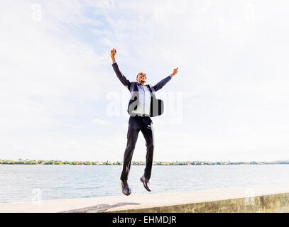 Black businessman jumping for joy outdoors Stock Photo