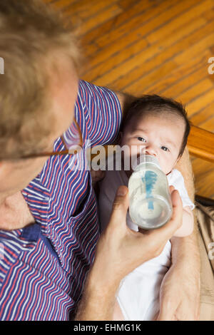 High angle view of father bottle feeding baby Stock Photo