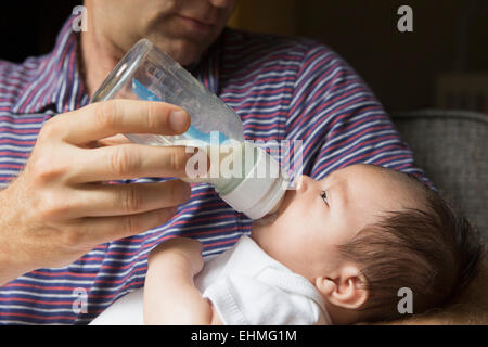 Close up of father bottle feeding baby Stock Photo