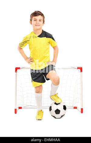 Full length portrait of a junior soccer player standing in front of a small goal isolated on white background Stock Photo
