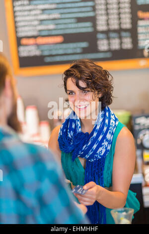 Mixed race cashier talking to customer in cafe Stock Photo