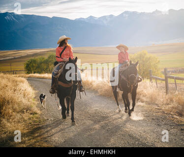 Caucasian mother and son riding horses on ranch Stock Photo