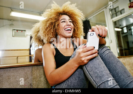 Hispanic dancer using cell phone in studio Stock Photo