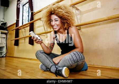 Hispanic dancer using cell phone in studio Stock Photo