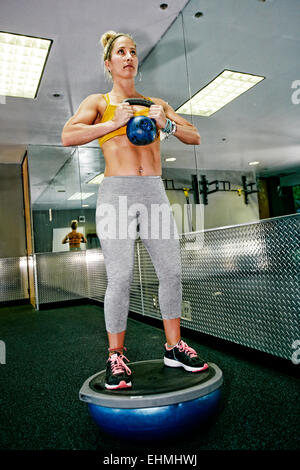Caucasian woman lifting weights in gym Stock Photo