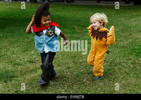 Boys playing in costumes in park Stock Photo