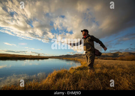 Fisherman casting in river Stock Photo