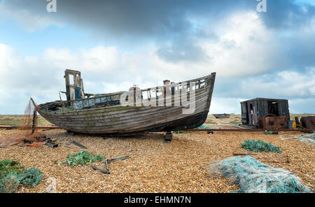 Abandoned fishing boat ad fisherman's hut on the beach at Dungeness in Kent Stock Photo