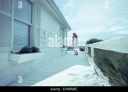 Caucasian woman walking on porch Stock Photo