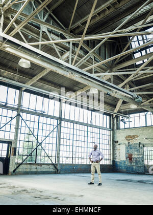 Black businessman standing in empty warehouse Stock Photo