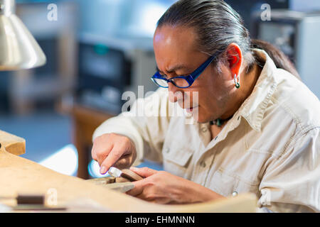 Close up of Native American jeweler working in studio Stock Photo