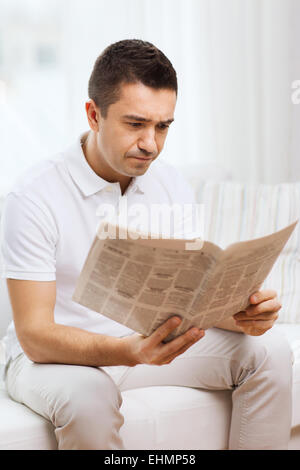 sad man reading newspaper at home Stock Photo