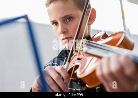 Close up of Caucasian boy playing violin Stock Photo