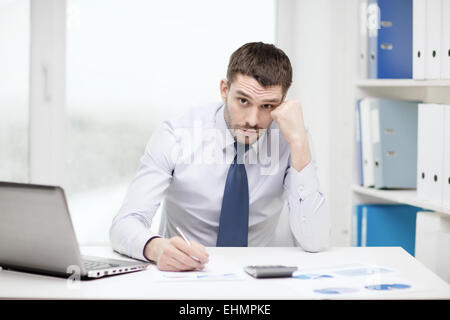 stressed businessman with laptop and documents Stock Photo