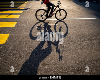 Cycling in the city with shadows from the morning sun Stock Photo