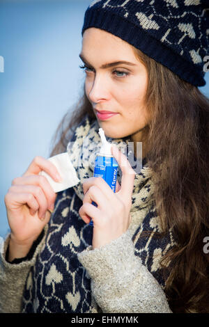 Woman using a sterile sea water spray. Stock Photo