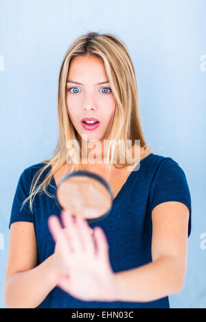 Woman using a magnifying glass to examine her hand. Stock Photo