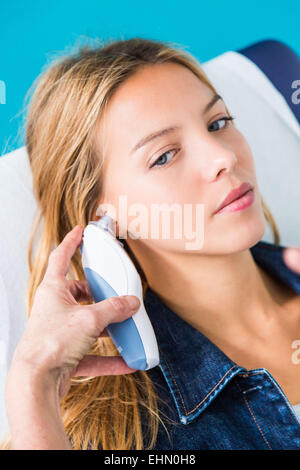 Checking the temperature of a patient with tympanic thermometer. Stock Photo