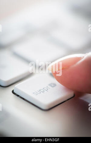 Woman pressing a button on a computer keyboard. Stock Photo