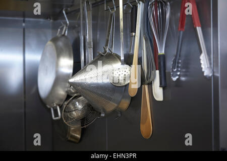 https://l450v.alamy.com/450v/ehn3pr/utensils-hanging-up-in-a-professional-kitchen-ehn3pr.jpg