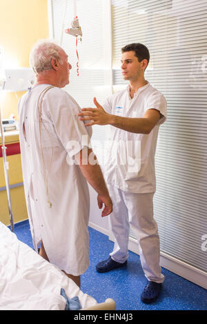 Man after a stroke doing physiotherapy exercises with a physiotherapist. Bordeaux hospital, France. Stock Photo