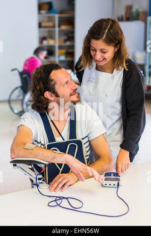 Hemiplegic patient after a stroke, and occupational therapist during an electrostimulation session, Department of Physical Medicine and Rehabilitation Hospital of Bordeaux hospital, France. Stock Photo