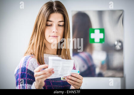 Woman reading medicine instruction sheet. Stock Photo