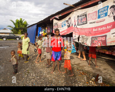 Dekai, Indonesia - January 12, 2015: The local  market, with colourfully dressed people. On the site, people sitting on chairs a Stock Photo