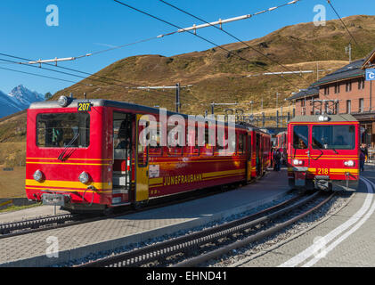 Red trains of the Jungfraubahn on the station Kleine Scheidegg in Switzerland. Stock Photo