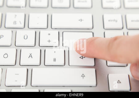finger on enter button on keyboard Stock Photo