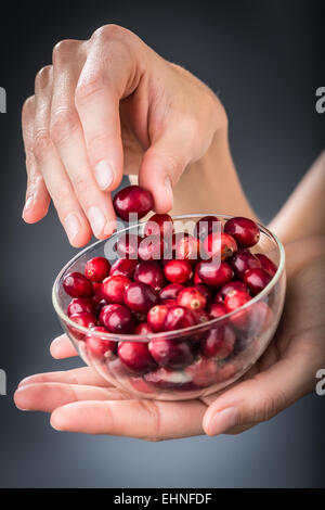 Woman eating dried cranberries. Stock Photo