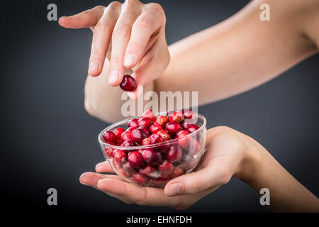 Woman eating dried cranberries. Stock Photo