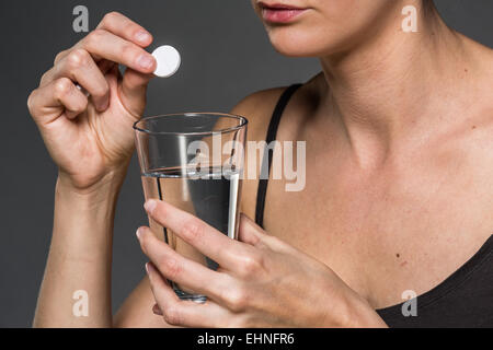 Woman taking an effervescent tablet. Stock Photo