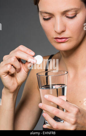 Woman taking an effervescent tablet. Stock Photo