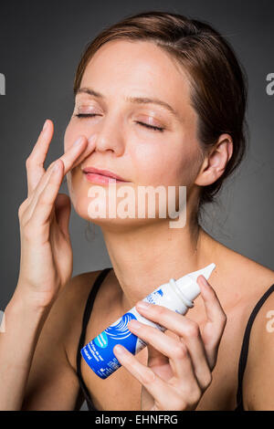 Woman using a sterile sea water spray. Stock Photo