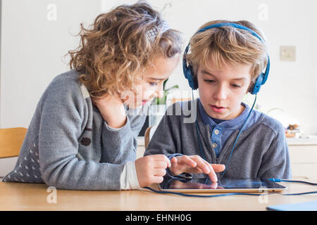 5 year old girl and 8 year old boy using tablet computer. Stock Photo