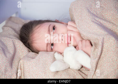 13 year old girl lying on her bed, reading - Stock Image - F032/2994 -  Science Photo Library