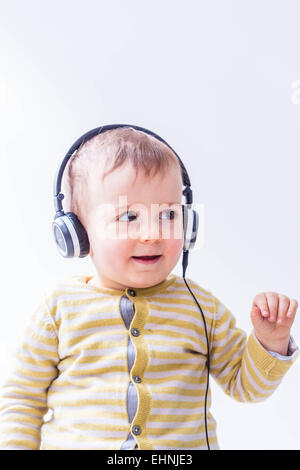 18 month-old baby boy listening music. Stock Photo