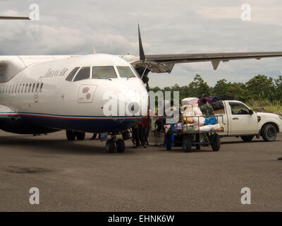 Dekai, Indonesia - January 12, 2015:  Aircraft being unloaded by local airline ground services staff Stock Photo